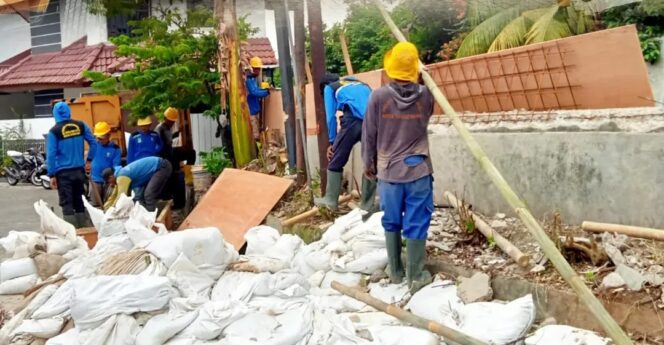 
 Petugas Dinas PUPR Kota Tangerang saat merehabilitasi turap di Kali Cantiga, Komplek Perdagangan (RW 08) dan saluran air silang atau drainase crossing di Jalan Arjuna RT 01/RW 013, Kelurahan Karang Timur, Kecamatan Karang Tengah. Foto: ist