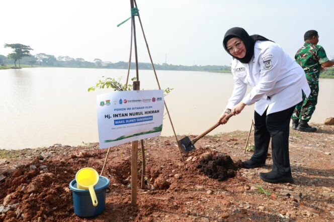 
 Wakil Bupati Tangerang, Intan Nurul Hikmah Saat Menanam Pohon Ketapang Kencana pada acara Penanaman 1000 Pohon dalam rangka memperingati Hari Bumi Tahun 2026 di Situ Cihuni Kec. Pagedangan. Foto: Ist