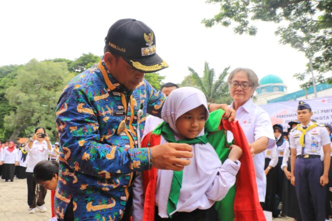 
 Pj Wali Kota Tangerang Dr Nurdin, S.Sos.,M.Si saat memakaikan rompi kepada salah satu siswi SD. Foto: ist