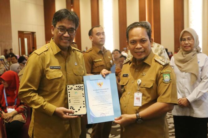 
 Penjabat Wali Kota Tangerang Dr Nurdin saat Menyerahkan Piagam Penghargaan Audit Sistem Kearsipan Internal (ASKI) kepada Kepala Dinas Perkimta Kota Tangerang, Decky P. Koesrindartono. Foto: ist