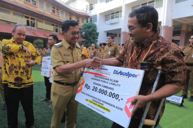 
 Wali Kota Tangerang, Sachrudin saat menyerahkan klaim asuransi public liability kepada warga yang terdampak musibah pohon tumbang. Foto: ist