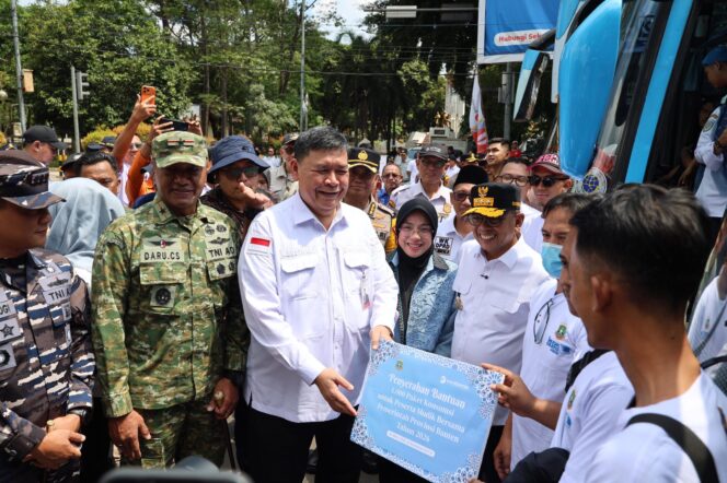 
 Direktur Utama Bank Banten Muhammad Busthami saat menyerahkan Paket bingkisan kepada para peserta mudik gratis. Foto: ist