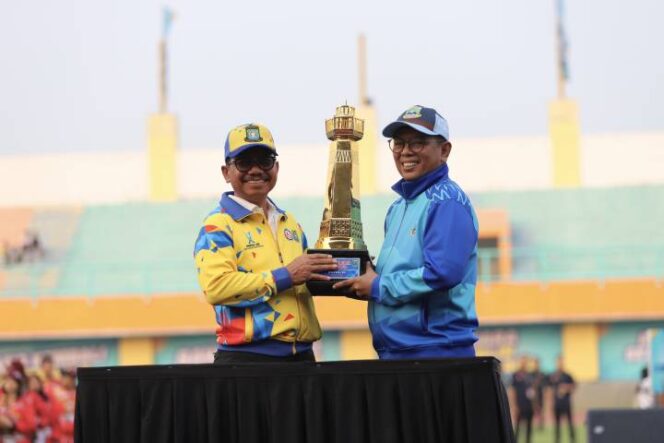 
 Wali Kota Tangerang Sachrudin saat menyerahkan piala bergilir POPDA kepada Gubernur Banten Andra Soni. Foto: ist