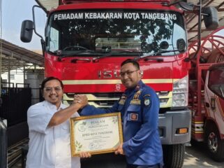 Katim Kedaruratan BPBD Kota Tangerang, Sarpa Wasesa saat menerima penghargaan dari Koordinator Koalisi Aktivis Lingkungan Hidup Tangerang (Kalung), Ade Yunus. Foto: TangerangPos 