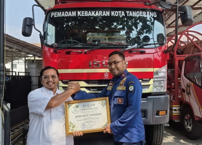 
 Katim Kedaruratan BPBD Kota Tangerang, Sarpa Wasesa saat menerima penghargaan dari Koordinator Koalisi Aktivis Lingkungan Hidup Tangerang (Kalung), Ade Yunus. Foto: TangerangPos 