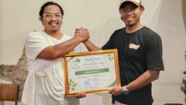 Bendahara Kawan Muda 17, Sangaji saat menerima penghargaan dari Koordinator Koalisi Aktivis Lingkungan Hidup Tangerang (Kalung), Ade Yunus. Foto: TangerangPos 
