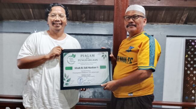 Koordinator Koalisi Aktivis Lingkungan Hidup Tangerang (Kalung), Ade Yunus menyerahkan piagam penghargaan kepada tokoh masyarakat Abah H.Edi Maskur yang telah berkontribusi membantu perbantuan logistik Penanganan TPA Jatiwaringin. Foto: Ist