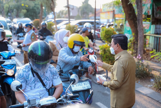 
 Wali Kota Tangerang, Sachrudin, bersama jajaran perangkat daerah terkait turun langsung membagikan masker kepada masyarakat, khususnya pengguna jalan, di kawasan Tugu Adipura. Foto: Ist