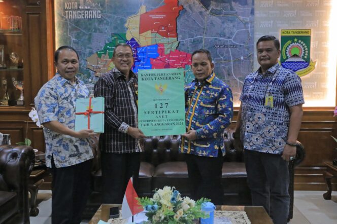 
 Kepala Kantor Pertanahan (Kakantah) Kota Tangerang, Muh. Yusuf menyerahkan 127 Sertipikat Aset dan 23 Sertipikat Hak Pakai Elektronik Barang Milik Daerah (BMD) kepada Pj Wali Kota, Dr.Nurdin. Foto: ist