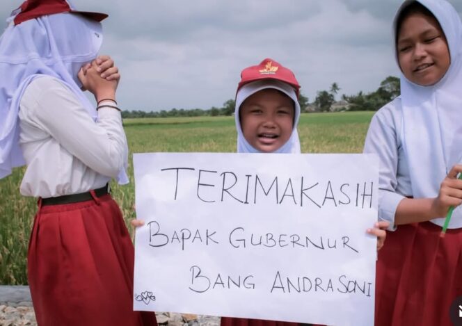 
 Siswi SDN Sindang Panon Kabupaten Tangerang Bentangkan Kertas Karton berisi ucapan terima kasih kepada Gubernur Banten usai jalan yang setiap hari dilaluinya menuju sekolah kini mulus usai dibangun melalui Program Bangun Jalan Desa Sejahtera (Bang Andra). Foto: Awal Rijal 