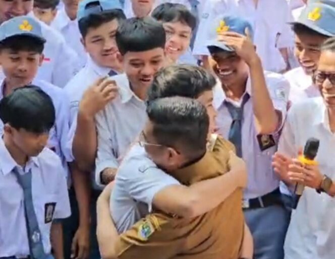
 Siswa kelas X SMK Pandeglang, Abdoel Hafidz memeluk sebagai ungkapan rasa syukur atas Program Sekolah Gratis yang telah membantunya melanjutkan pendidikan. Foto: Ist