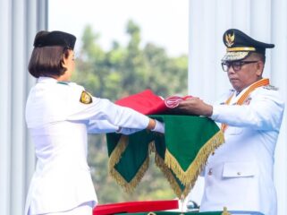 Gubernur Banten Andra Soni menyerahkan Bendera Merah Putih kepada Paskibraka. Foto: Ist