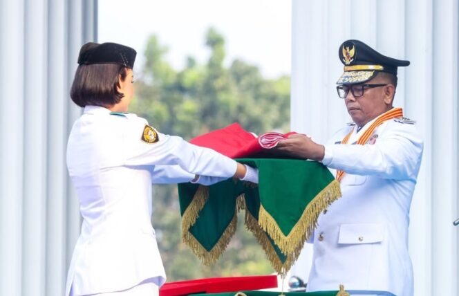 
 Gubernur Banten Andra Soni menyerahkan Bendera Merah Putih kepada Paskibraka. Foto: Ist
