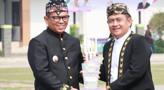Gubernur Banten Andra Soni saat menyerahkan Penghargaan Kepada Camat Kelapa Dua Dadang Sudrajat. Foto: Iat