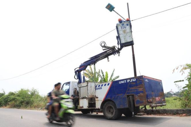 
 Personel Dishub Kota Tangerang saat melakukan perbaikan penerangan jalan umum (PJU). Foto: Ist