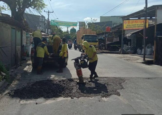 
 Petugas DPUPR Kota Tangerang memperbaiki jalanan rusak di sepanjang Jalan Raya Kutabumi-Periuk.Foto: ist