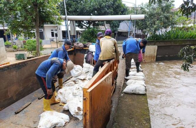 
 Petugas DPUPR Kota Tangerang memasang kisdam darurat di Perumahan Duren Village, Kelurahan Sudimara Selatan, Kecamatan Ciledug, Kota Tangerang. Foto: ist