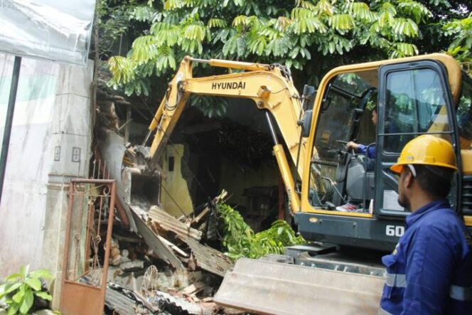 
 Petugas DPUPR Kota Tangerang menggunakan alat berat untuk pembongkaran bangunan di Bantaran Kali Angke, Kelurahan Pedurenan, Kecamatan Karang Tengah, Kota Tangerang, Provinsi Banten. Foto: ist